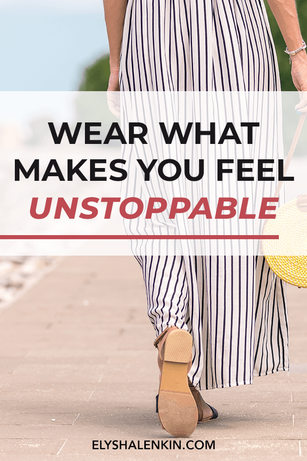 Wear what makes you feel unstoppable. Women wearing black and white striped jumpsuit walking down a path. She has a straw handbag and wear sandals.
